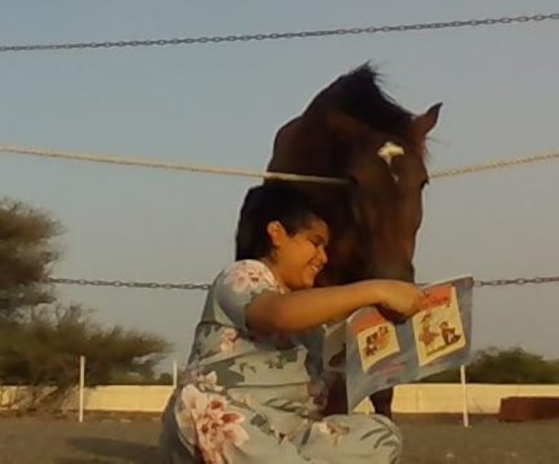 بالصور: طفلة عمانية تقرأ الكتب للحيوانات