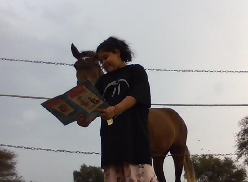 بالصور: طفلة عمانية تقرأ الكتب للحيوانات