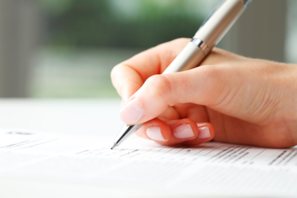 Businesswoman writing on a form